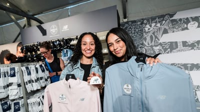 Two women pose for a photo with New Balance clothes in the New Balance store at the 2025 RBC Brooklyn Half Pre-Party