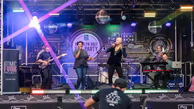 Two singers perform on stage at the 2025 RBC Brooklyn Half Pre-Party