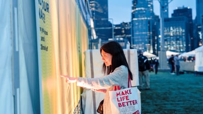 A woman searches for her name on the name wall at the 2025 RBC Brooklyn Half Pre-Party