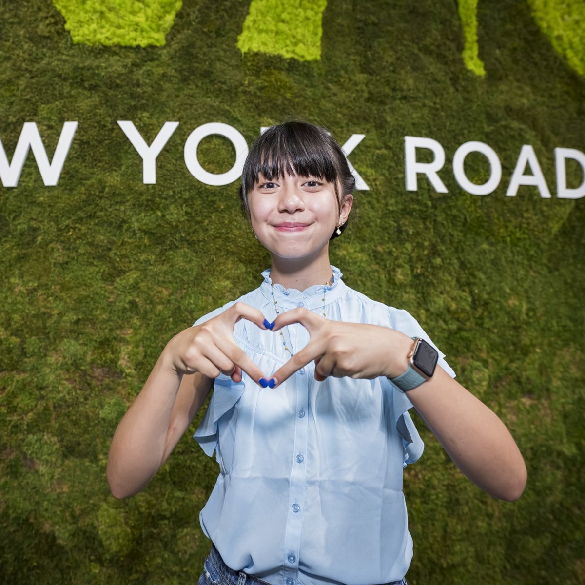 Youth Ambassador making a heart sign with her hands