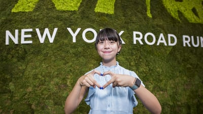 Youth Ambassador making a heart sign with her hands