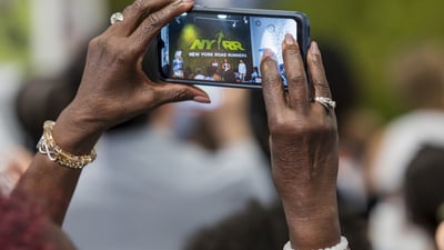 Someone taking a picture on their phone of the Youth Ambassador graduation ceremony at the NYRR RUNCenter