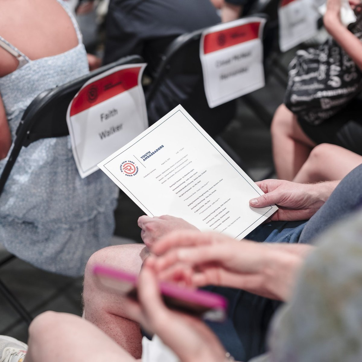 Someone holding and looking at the program for the youth ambassador graduation