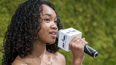A youth ambassador speaks into a mic