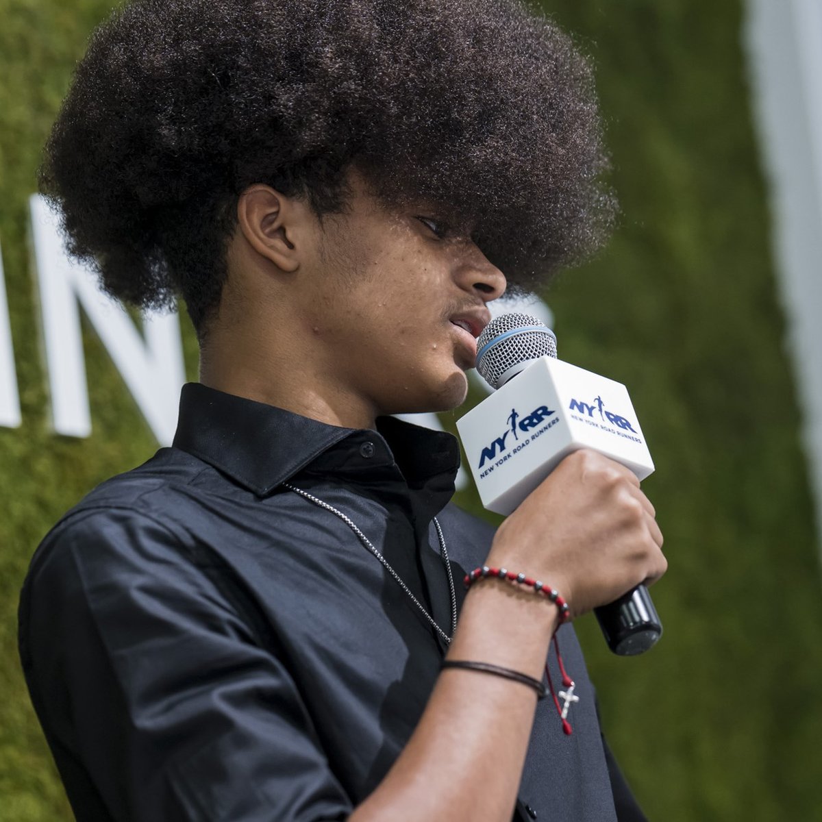 A youth ambassador speaks into a mic at graduation