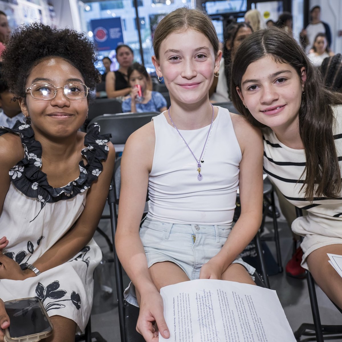 Three female youth ambassadors smile for a picture at graduation