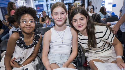 Three female youth ambassadors smile for a picture at graduation
