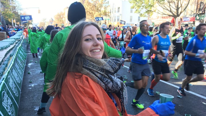 A volunteer with the Exchange Visitor Program hands out water during the TCS NYC Marathon.