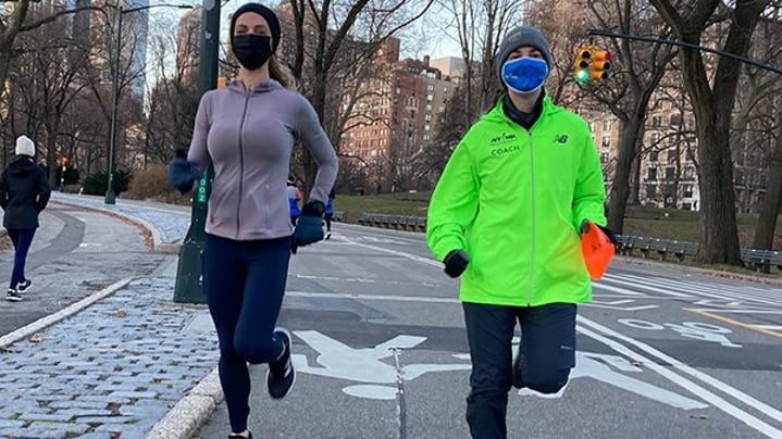 Female runner and female coach in Central Park wearing masks and winter clothing