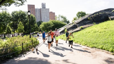 Group of runners running in a park on a sunny day