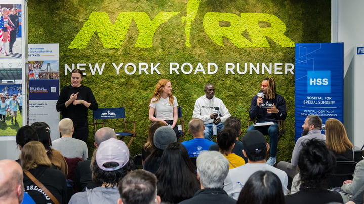 Three athletes speak on a panel in front of an audience at NYRR's Run Center