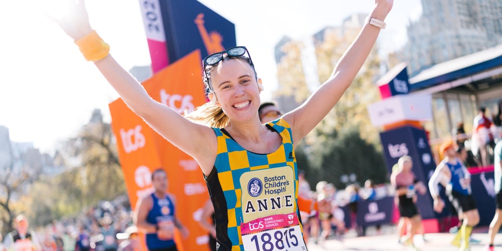 2024 TCS NYC Marathon finisher with arms raised