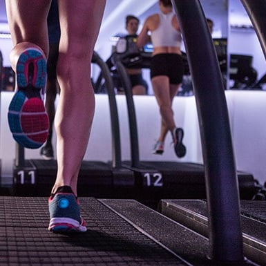 Photo of peoples legs while they run on treadmills