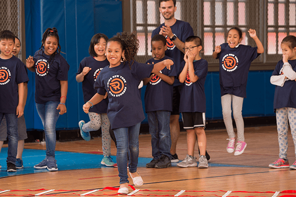 Children running in a school gymnasium