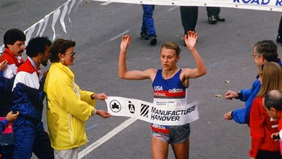 Grete Waitz breaking tape at NYC Marathon