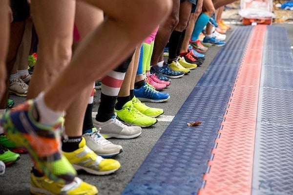 Runners line up on the timing mat of a race.