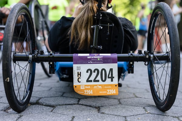 Image of the back of an athlete with disability and their Achilles race bib.