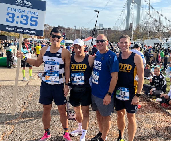 NYRR Pace Team member Henry Wang stands with NYPD runners at the start of the TCS New York City Marathon.