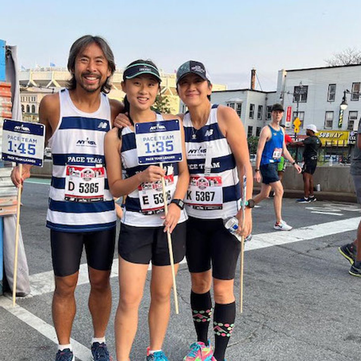 NYRR Pace Team members the Lam Family pose with pace signs.