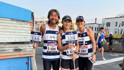 NYRR Pace Team members the Lam Family pose with pace signs.