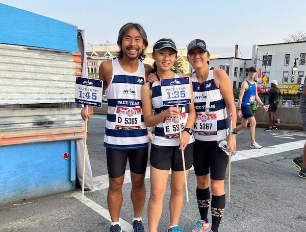NYRR Pace Team members the Lam Family pose with pace signs.