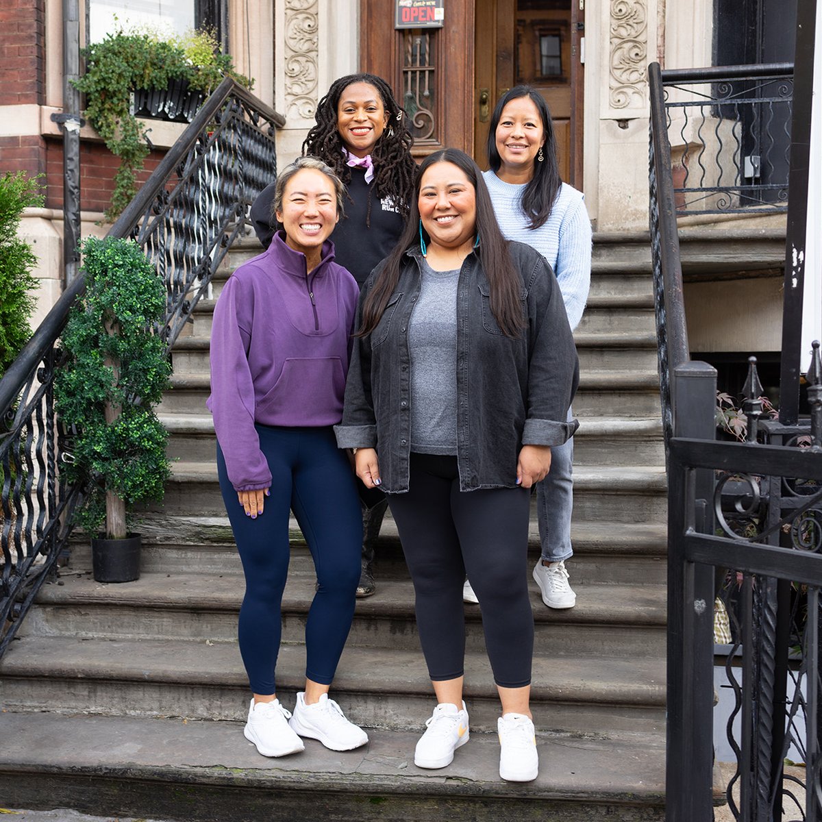 NYRR Contributors Circle members standing on steps at Harlem Run House November 2023
