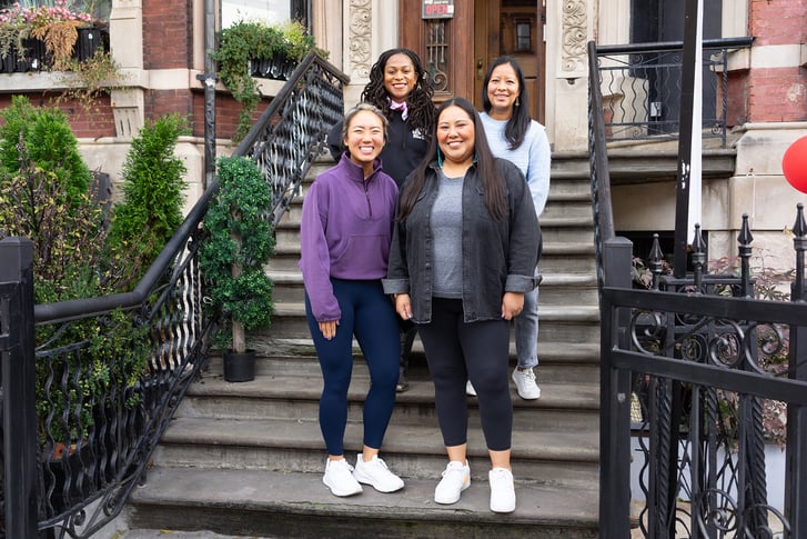 NYRR Contributors Circle members standing on steps at Harlem Run House November 2023