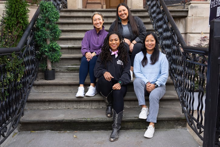 NYRR Contributors Circle members sitting on steps at Harlem Run House November 2023