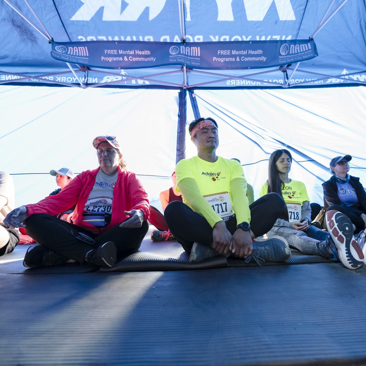 Runners in tent meditating before 2024 NYRR Mindful 5K