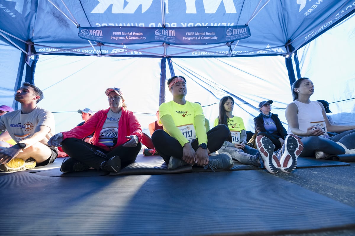 Runners in tent meditating before 2024 NYRR Mindful 5K
