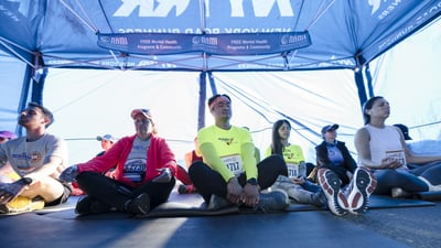 Runners in tent meditating before 2024 NYRR Mindful 5K