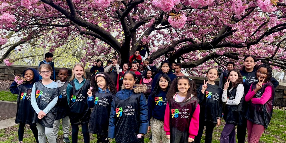 PS 75 running club kids gathered under flowering tree in Riverside Park