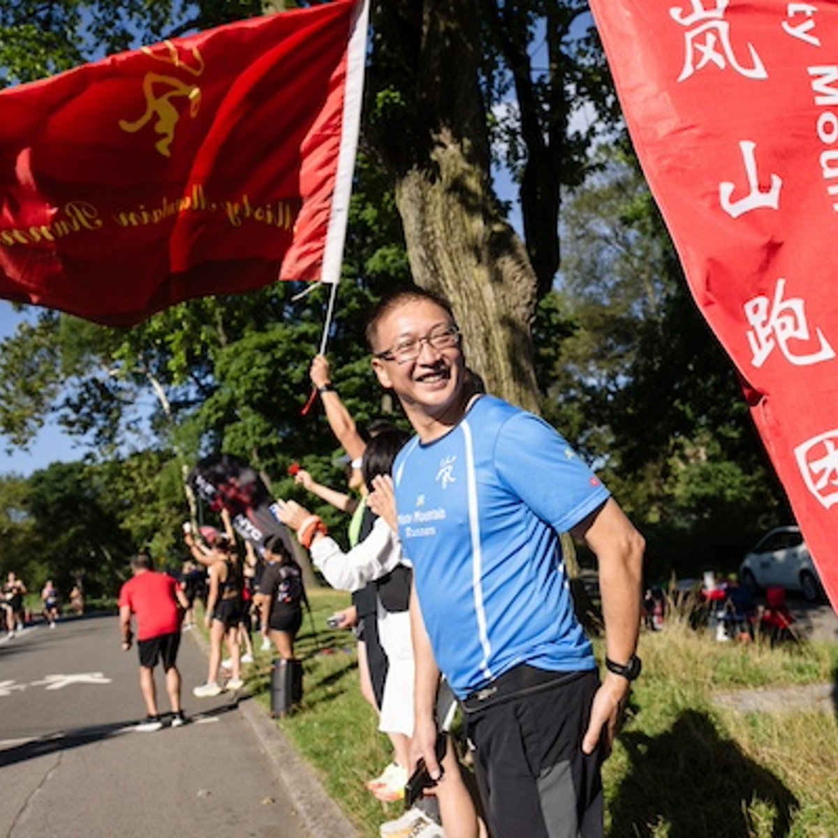 Misty Mountain Runners cheering along the course with flag.