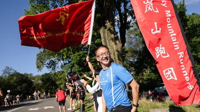 Misty Mountain Runners cheering along the course with flag.