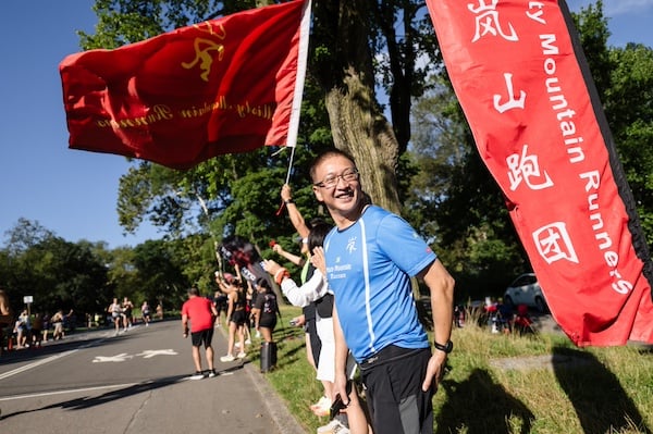 Misty Mountain Runners cheering along the course with flag.