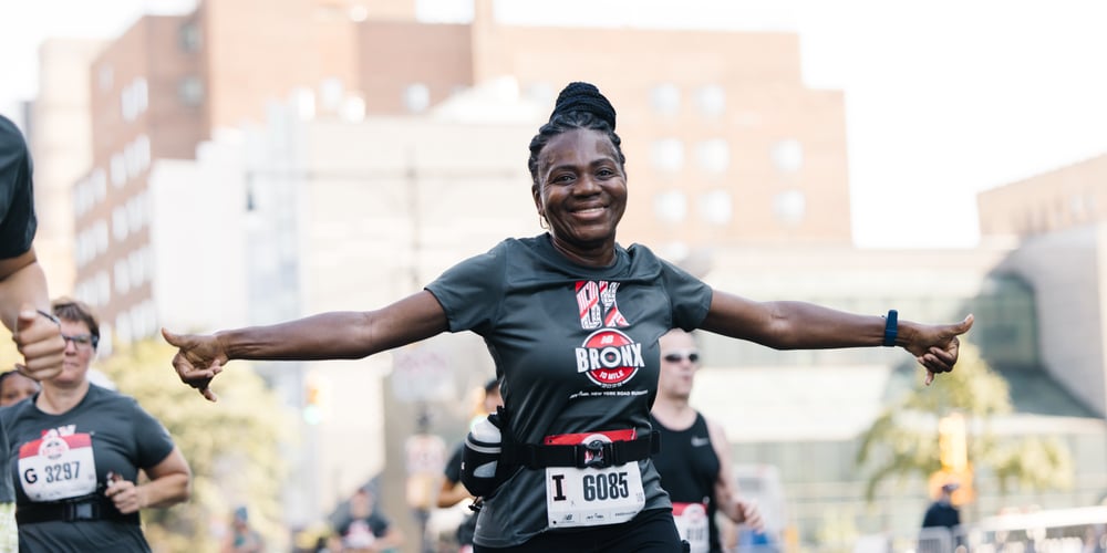Smiling woman running 2023 New Balance Bronx 10 Mile September 2023