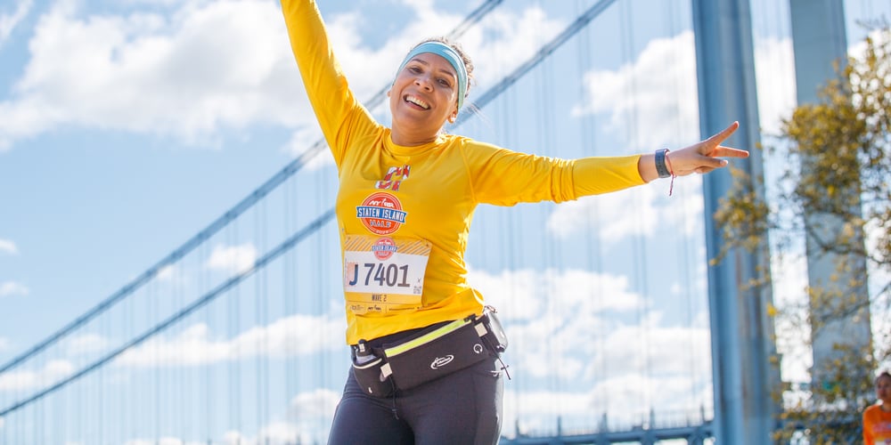 2023 NYRR Staten Island Half runner with Verrazzano Bridge in background.