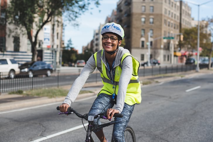Woman riding bike in the Bronx wearing a helmet