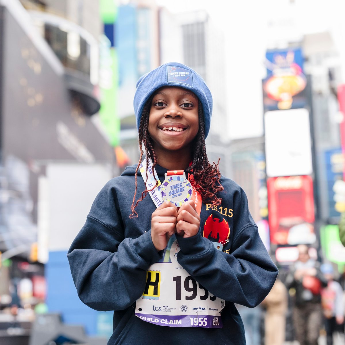 Child in Times Square with medal at Times Square Kids Run at 2024 UA NYC Half