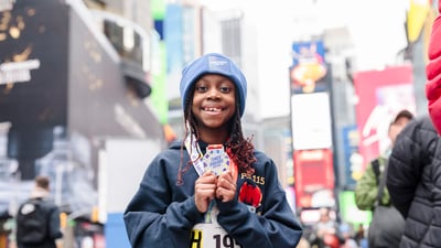 Child in Times Square with medal at Times Square Kids Run at 2024 UA NYC Half