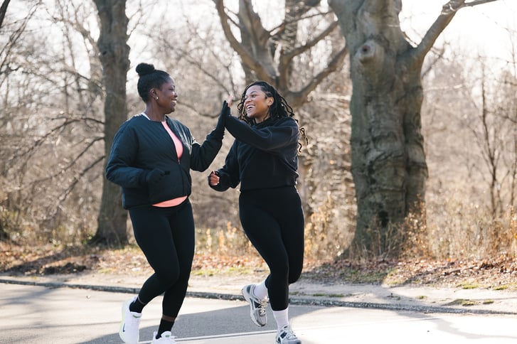 Cheryl Donald and Victoria Fortune running and high-fiving in Prospect Park