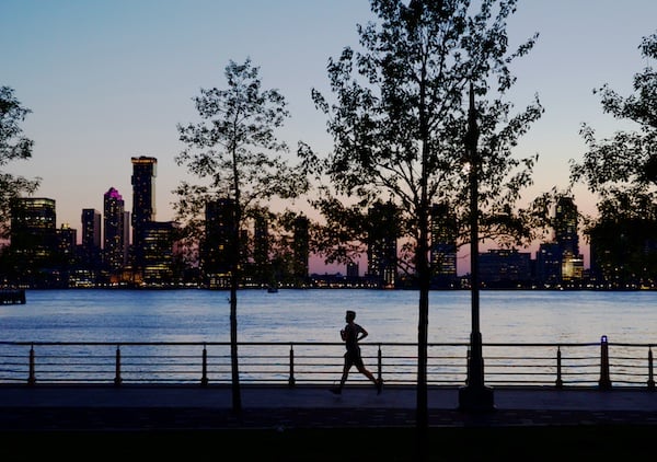A solo runner logging miles near the water at sunrise.