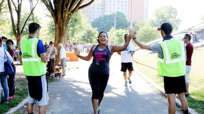 A runner high-fives event staff at St. Mary's Park