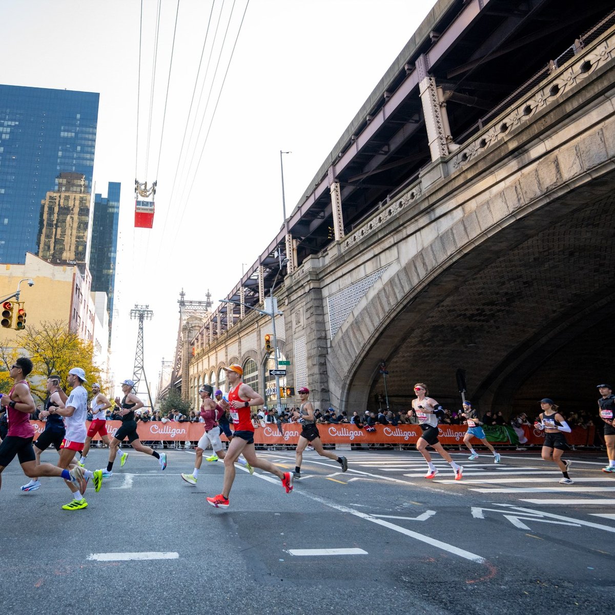Runners running out from under bridge