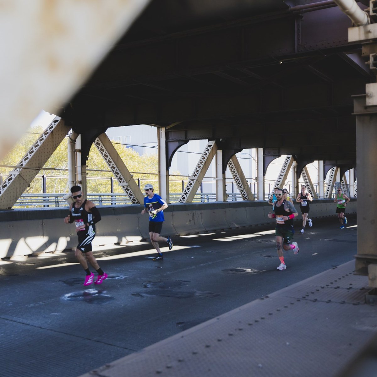 Runners running under bridge