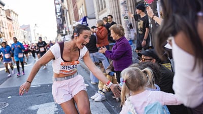 Runner high-fiving kids in crowd