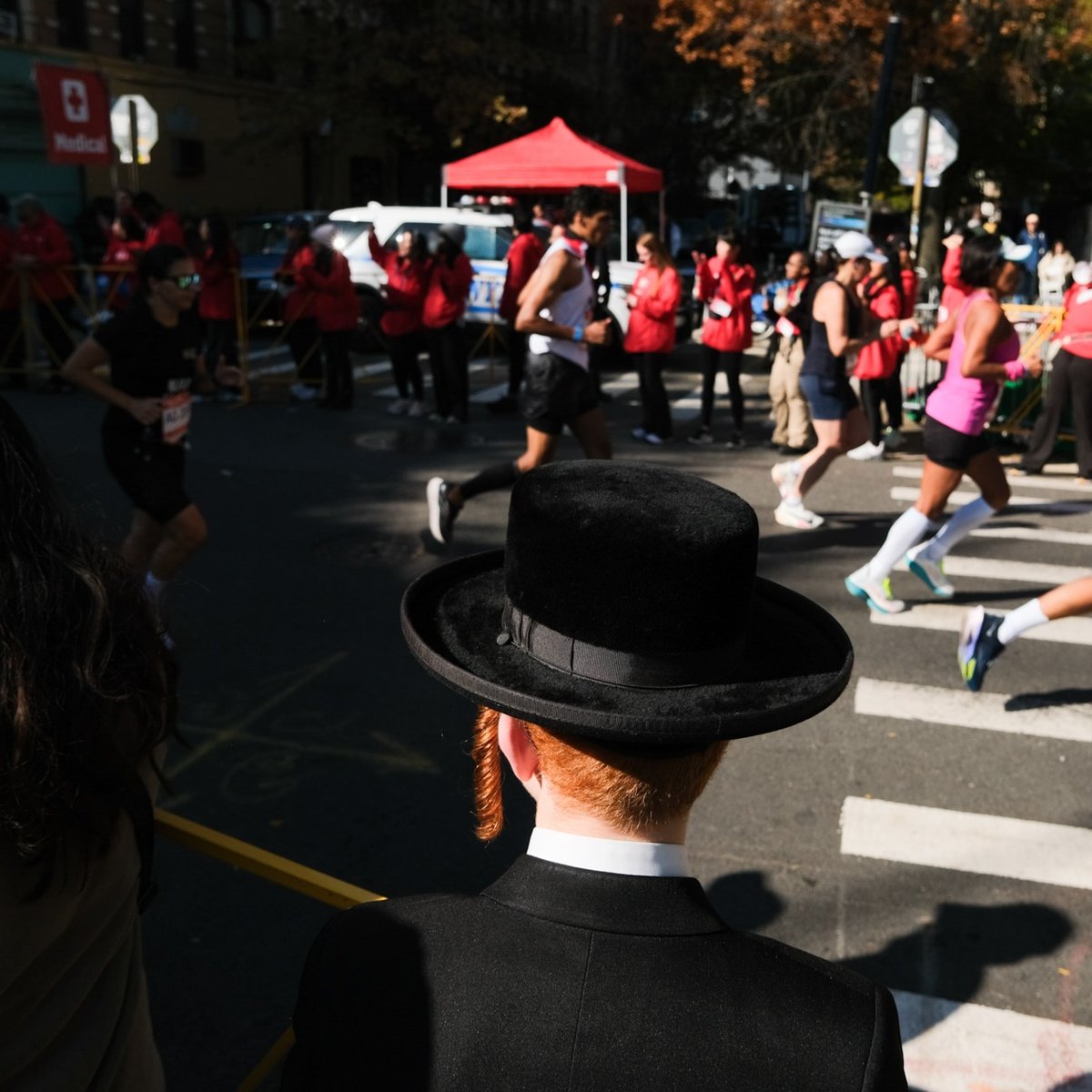 Man in hat watching runners