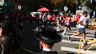 Man in hat watching runners