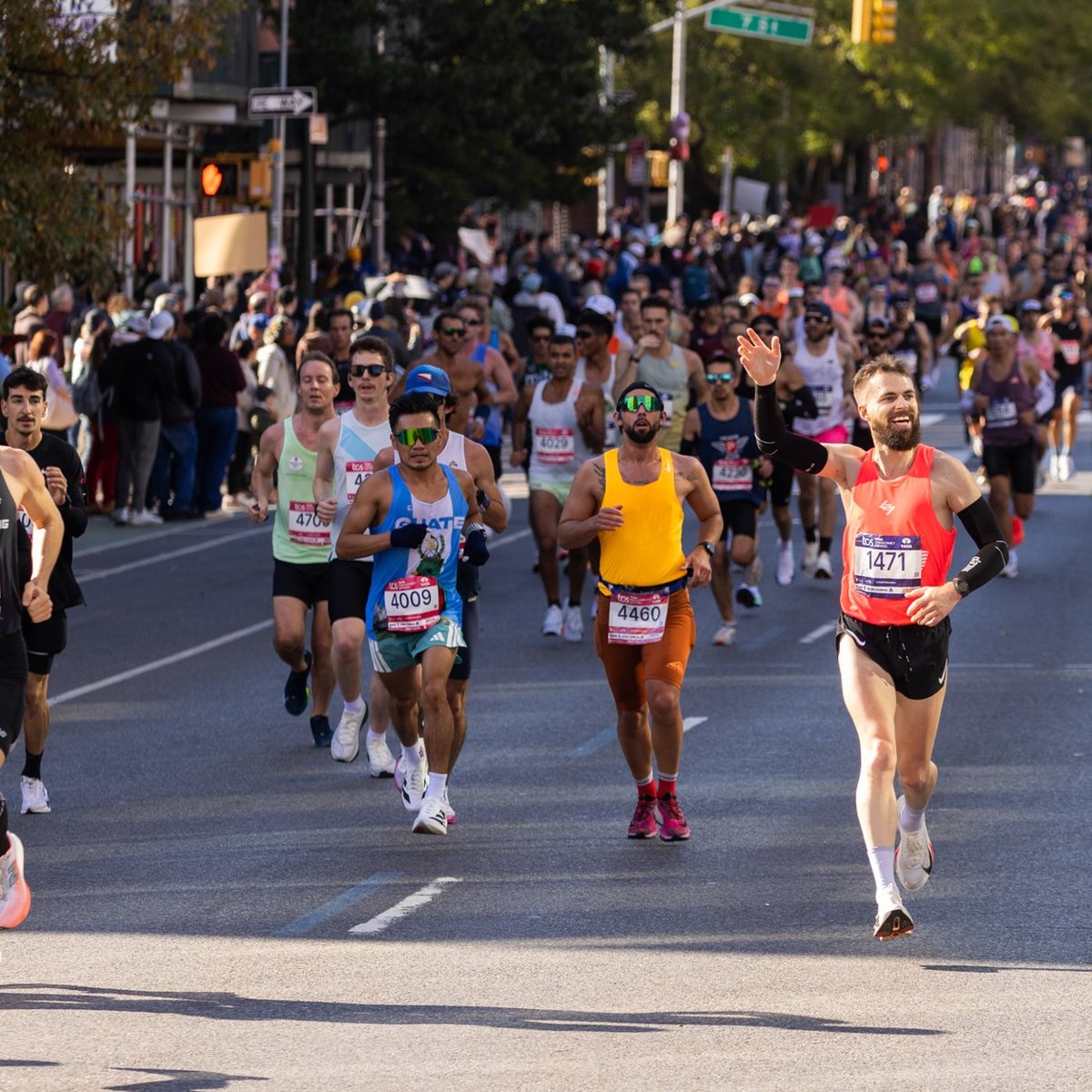 Crowd of runners with one runner waving