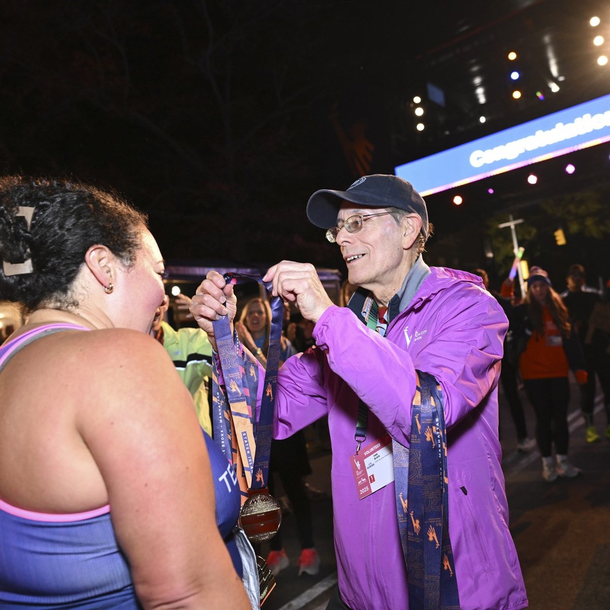 A female final finisher receives her medal at the finish line